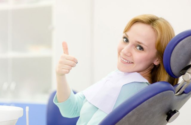 patient at the dentist giving thumbs up